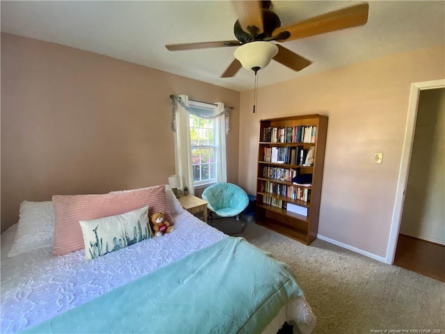 carpeted bedroom featuring baseboards and ceiling fan