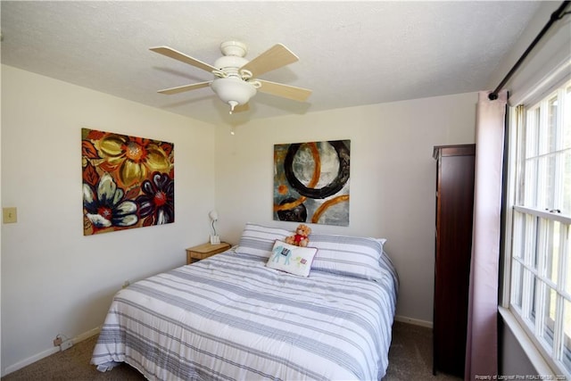 carpeted bedroom with baseboards, a ceiling fan, and a textured ceiling