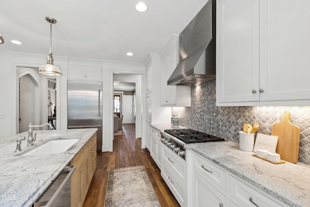 523 Vick Ave, Raleigh, NC 27612 - kitchen with a sink, appliances with stainless steel finishes, wall chimney exhaust hood, dark wood-style flooring, and white cabinets