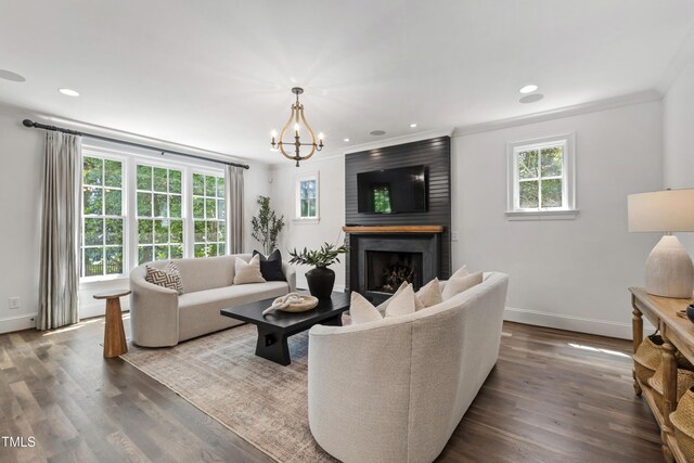 523 Vick Ave, Raleigh, NC 27612 - living room featuring baseboards, a fireplace, a chandelier, dark wood finished floors, and crown molding