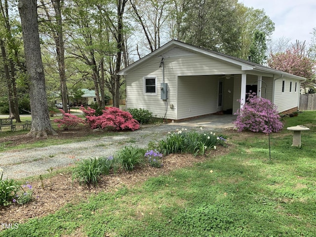 505 E Graham St, Mebane, NC 27302 - view of side of property with fence, a lawn, an attached carport, and driveway