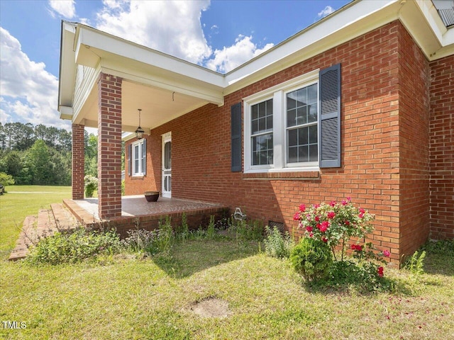 view of side of home with a lawn and brick siding