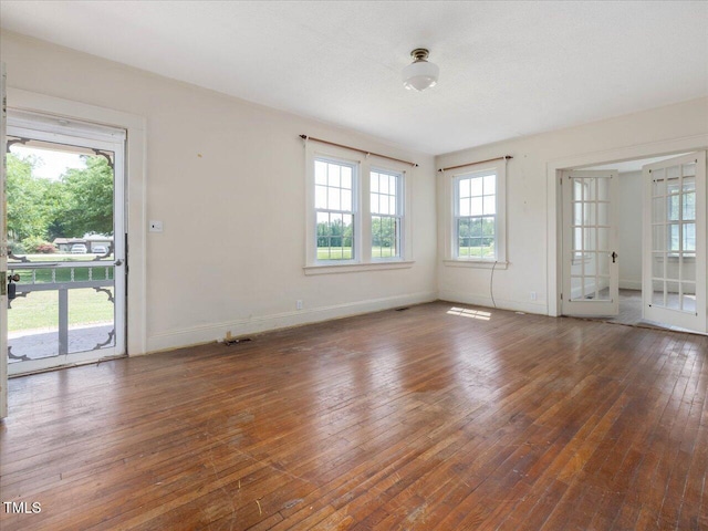 interior space with wood-type flooring, baseboards, and visible vents