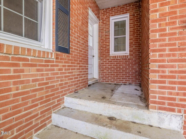 entrance to property featuring brick siding
