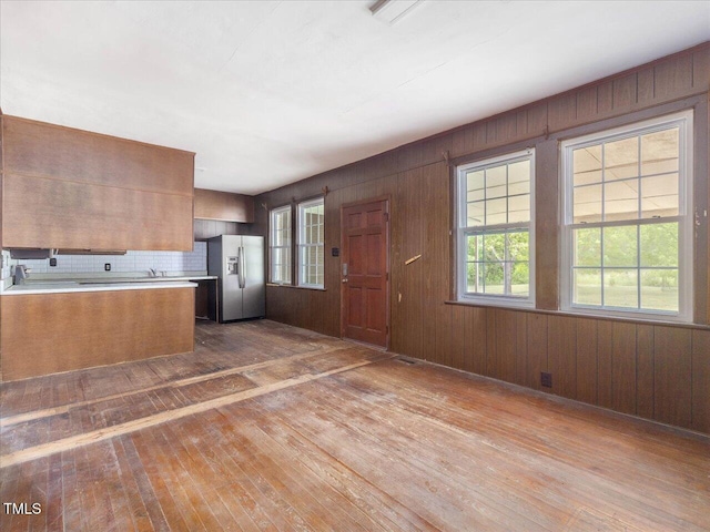 kitchen with light countertops, stainless steel fridge with ice dispenser, plenty of natural light, and hardwood / wood-style floors