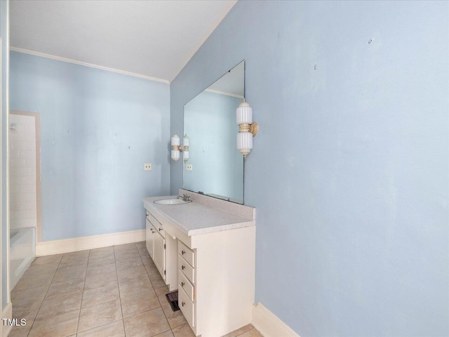 full bath with tile patterned flooring, vanity, baseboards, a tub to relax in, and ornamental molding
