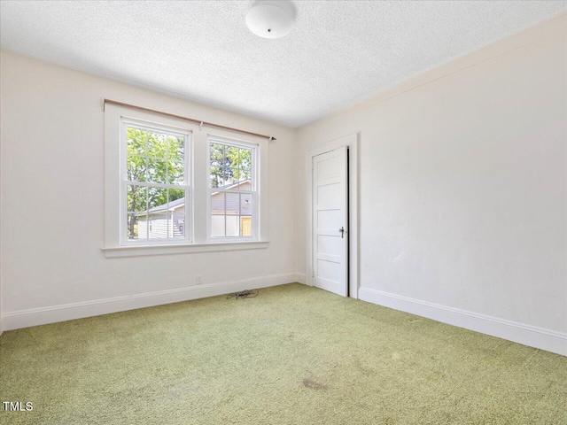 unfurnished room featuring baseboards, light carpet, and a textured ceiling