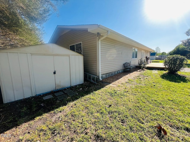 view of side of home with a shed, an outdoor structure, and a lawn
