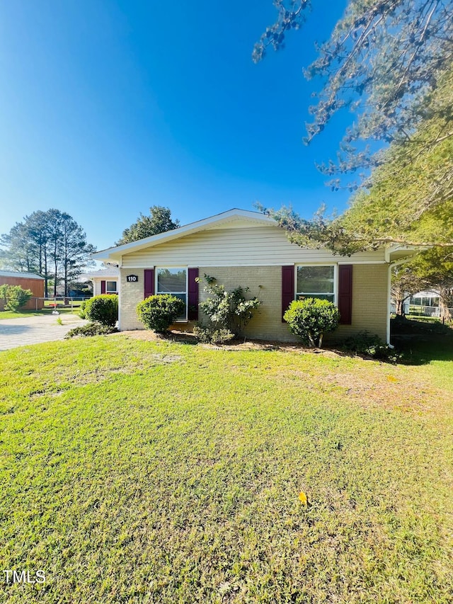 view of front of property with brick siding and a front lawn