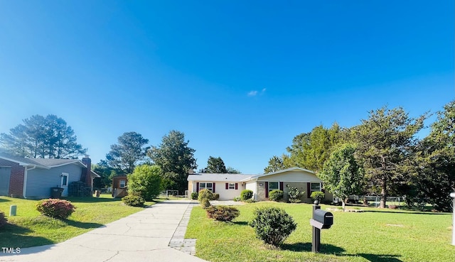 ranch-style home with a front lawn and concrete driveway