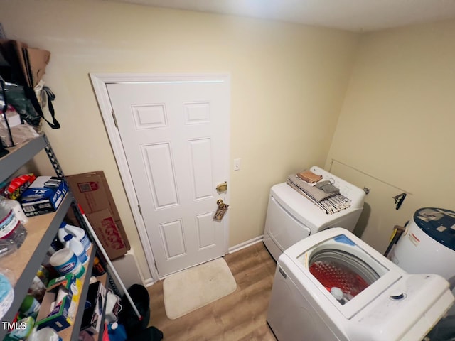 washroom with separate washer and dryer, laundry area, and wood finished floors