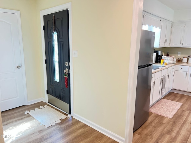 foyer entrance with light wood-type flooring and baseboards
