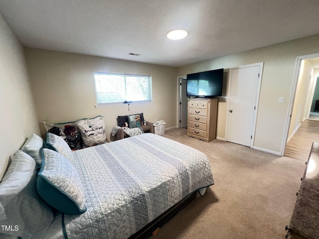 bedroom featuring visible vents, baseboards, and light colored carpet