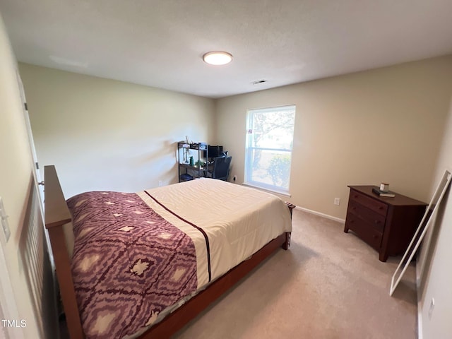 bedroom featuring visible vents, light colored carpet, and baseboards