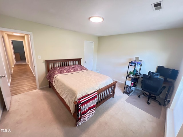 bedroom featuring light carpet, visible vents, and baseboards