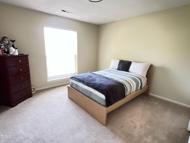 carpeted bedroom with baseboards and visible vents