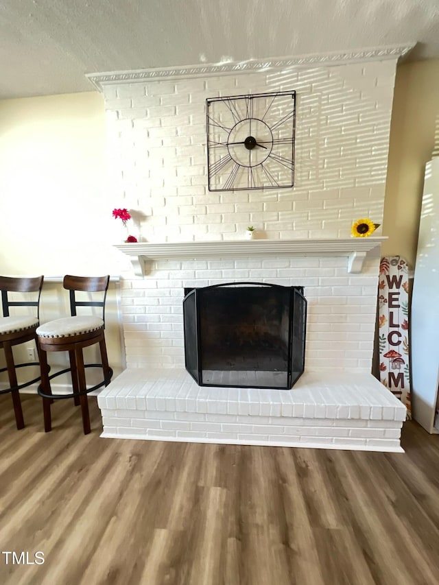 interior details with a fireplace, wood finished floors, and a textured ceiling