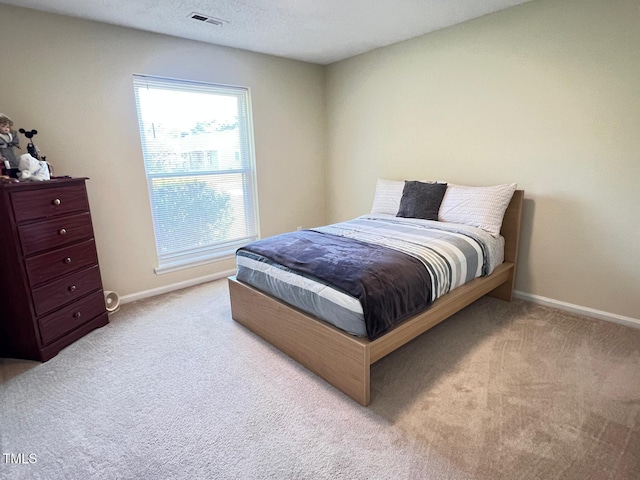 carpeted bedroom with visible vents and baseboards