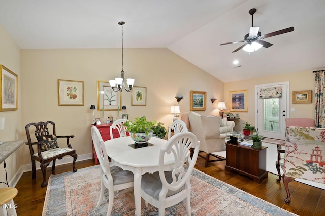 dining area with ceiling fan with notable chandelier, vaulted ceiling, visible vents, and dark wood-style flooring