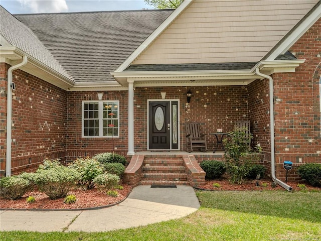property entrance with brick siding, roof with shingles, and a porch
