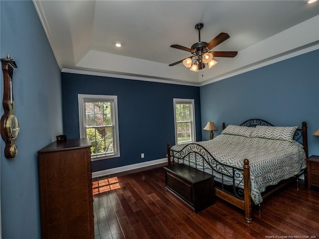 bedroom featuring dark wood-style flooring, a raised ceiling, baseboards, ornamental molding, and recessed lighting