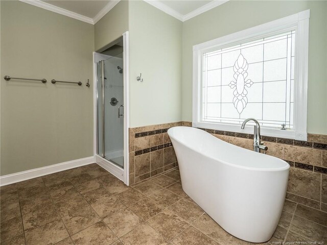 bathroom with tile walls, ornamental molding, and a stall shower