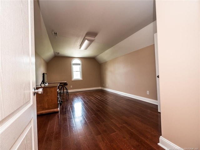 additional living space with wood-type flooring, baseboards, and vaulted ceiling
