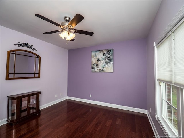 empty room with baseboards, wood finished floors, and a wealth of natural light