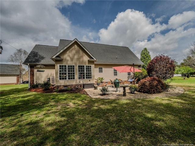 back of property with a lawn, a patio, and a shingled roof