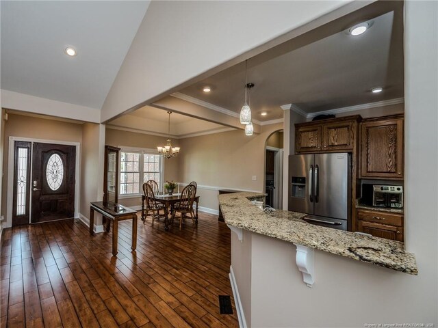 49 Alyssa Ct, Lumberton, NC 28360 - kitchen with stainless steel fridge with ice dispenser, baseboards, a breakfast bar area, light stone countertops, and pendant lighting