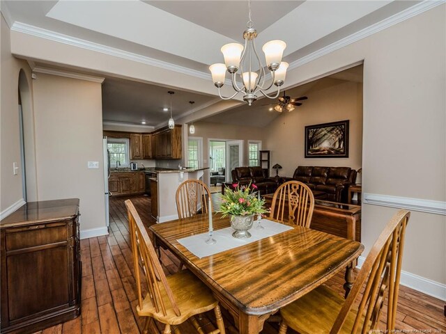 49 Alyssa Ct, Lumberton, NC 28360 - dining area featuring dark wood-type flooring, a chandelier, baseboards, ornamental molding, and lofted ceiling