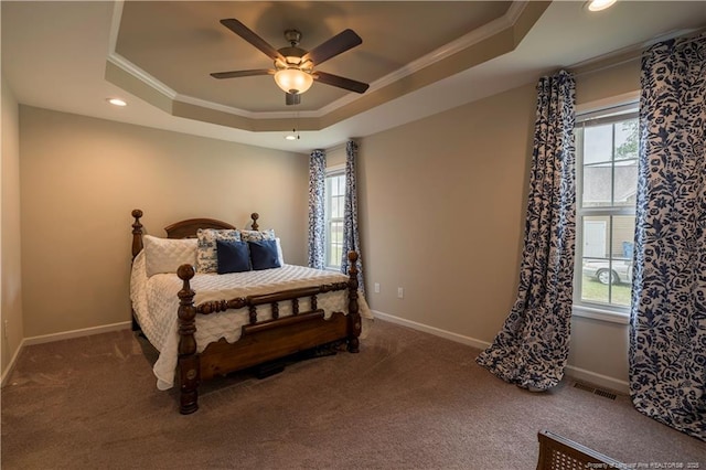 carpeted bedroom with crown molding, visible vents, baseboards, and a raised ceiling