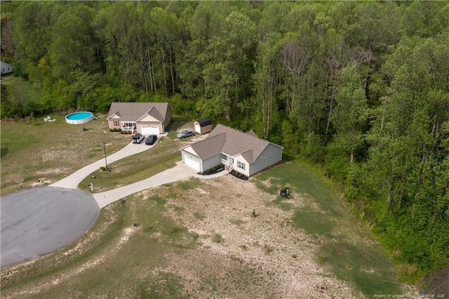 bird's eye view with a wooded view