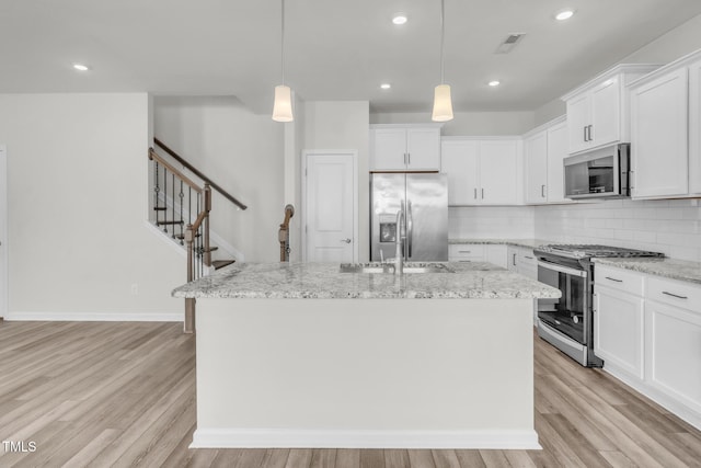 1412 Smoky Mountains St, Durham, NC 27713 - kitchen featuring tasteful backsplash, light wood-type flooring, visible vents, appliances with stainless steel finishes, and a kitchen island with sink
