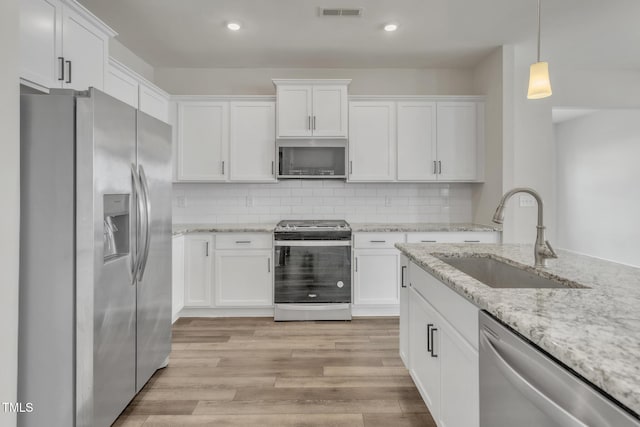 1412 Smoky Mountains St, Durham, NC 27713 - kitchen with white cabinets, visible vents, a sink, and appliances with stainless steel finishes