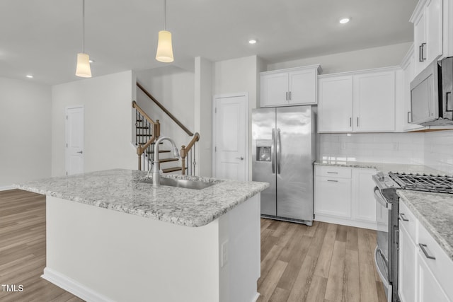 1412 Smoky Mountains St, Durham, NC 27713 - kitchen with appliances with stainless steel finishes, light wood finished floors, a sink, and white cabinets
