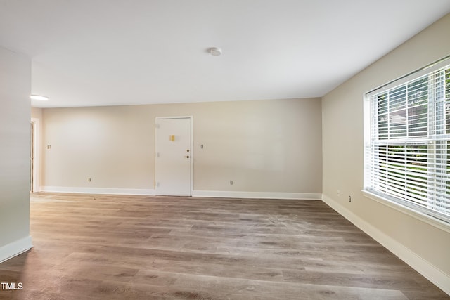 5804 Falls Of Neuse Rd Unit E, Raleigh, NC 27609 - empty room featuring baseboards, wood finished floors, and a smoke detector