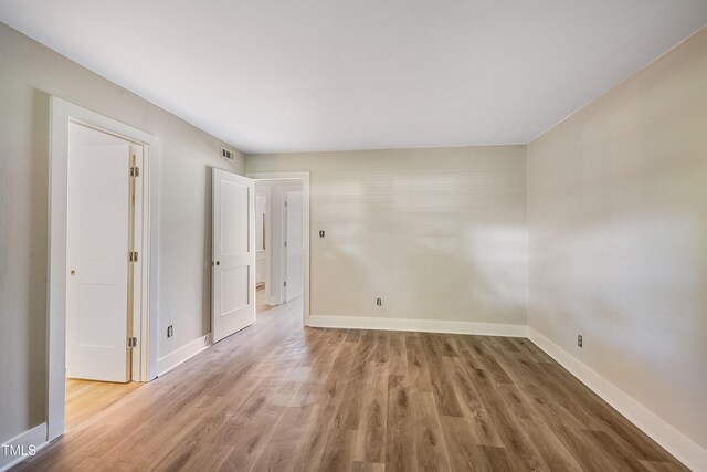 5804 Falls Of Neuse Rd Unit E, Raleigh, NC 27609 - empty room with wood finished floors and baseboards