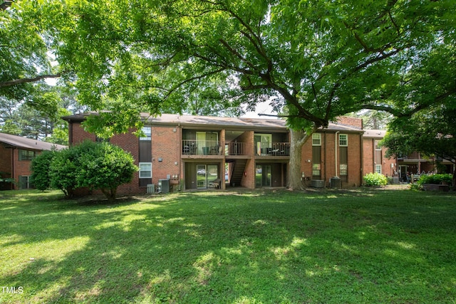 5804 Falls Of Neuse Rd Unit E, Raleigh, NC 27609 - back of house featuring brick siding, a yard, stairs, and cooling unit