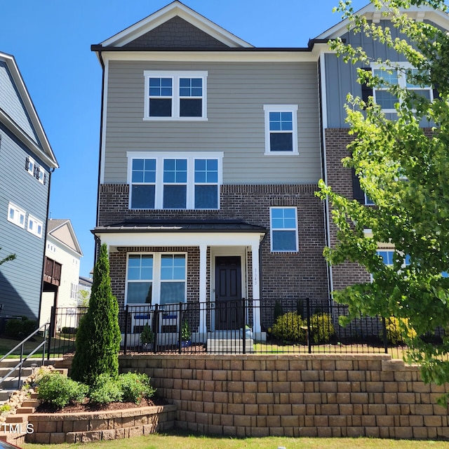 view of front facade with brick siding and fence private yard