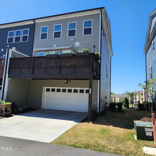 back of property featuring a lawn, an attached garage, and driveway