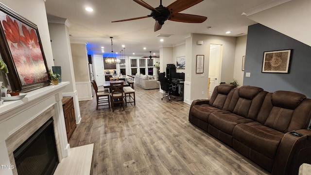 living area featuring recessed lighting, ceiling fan with notable chandelier, and a fireplace