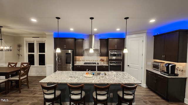 kitchen featuring appliances with stainless steel finishes, decorative backsplash, dark wood finished floors, and wall chimney exhaust hood