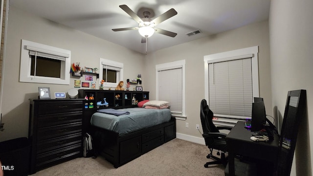 carpeted bedroom with a ceiling fan, baseboards, and visible vents