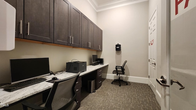 home office with built in study area, baseboards, ornamental molding, and carpet