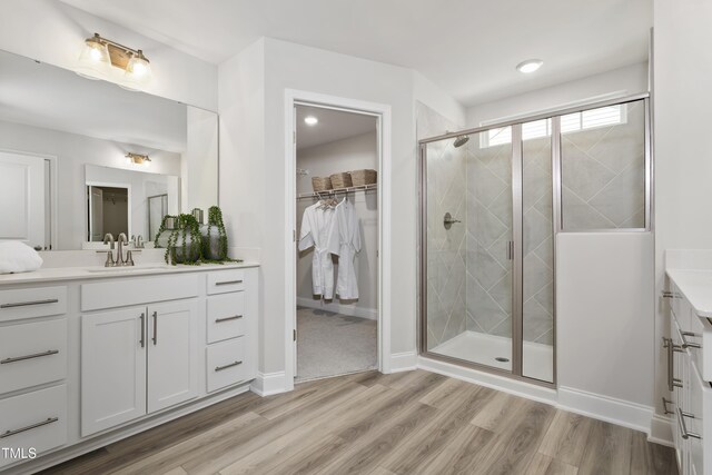 211 Faith Ave, Sanford, NC 27330 - bathroom with a spacious closet, vanity, a stall shower, and wood finished floors