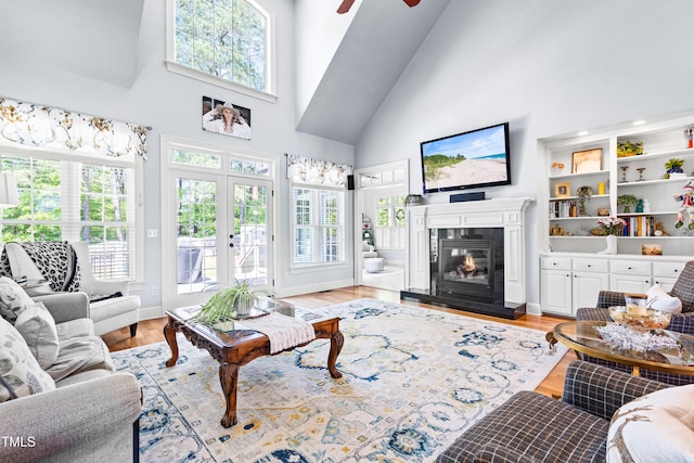 215 Terrell Dr, Rolesville, NC 27571 - living area with high vaulted ceiling, a ceiling fan, light wood finished floors, and a glass covered fireplace