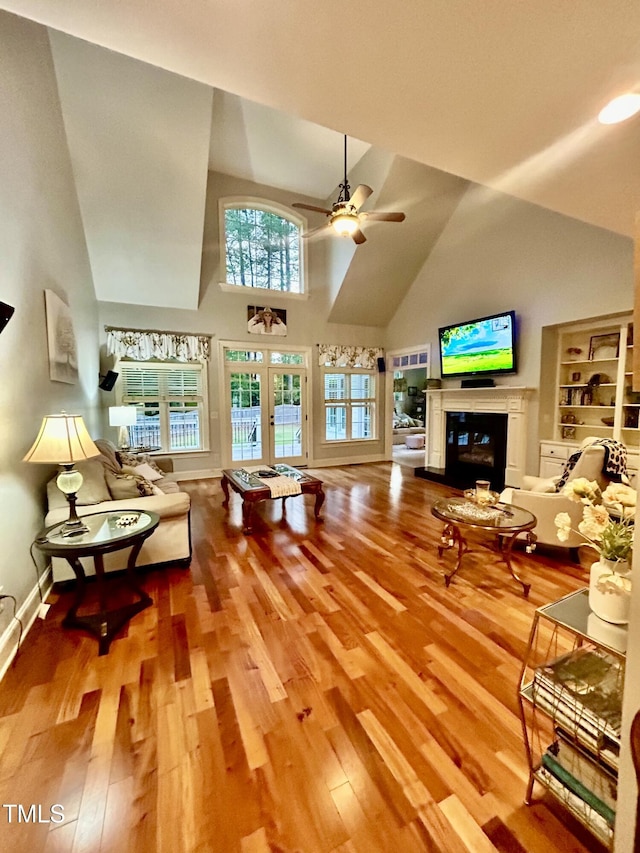 215 Terrell Dr, Rolesville, NC 27571 - living area with high vaulted ceiling, french doors, a glass covered fireplace, ceiling fan, and wood finished floors