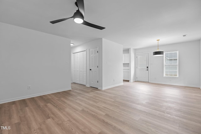 unfurnished living room with light wood-style floors, baseboards, and ceiling fan