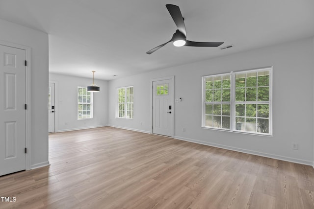 unfurnished living room with a ceiling fan, baseboards, and visible vents